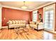 Living room features hardwood floors, two sofas, and a terracotta accent wall at 1411 River Station Dr, Lawrenceville, GA 30045