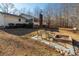 Spacious backyard with brick fire pit and chair setting; home with a screened in porch at 4286 Pool Rd, Winston, GA 30187