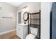 Modern bathroom with white vanity, decorative mirror, dark shelving, and luxury vinyl plank flooring at 4286 Pool Rd, Winston, GA 30187