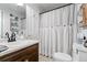 Bathroom with a wood vanity, patterned tile floor, and white shower curtain at 4286 Pool Rd, Winston, GA 30187