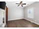 The large bedroom has a ceiling fan, wood floors, a window, and a rustic sliding wood barn door at 4286 Pool Rd, Winston, GA 30187