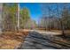 Long private driveway leading to a gated entrance, surrounded by mature trees at 4286 Pool Rd, Winston, GA 30187