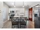 Modern kitchen with white cabinetry, stainless steel appliances, kitchen island with chairs, and a sliding barn door at 4286 Pool Rd, Winston, GA 30187