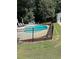 Backyard pool surrounded by a black metal fence and green landscaping with an outdoor seating area at 4286 Pool Rd, Winston, GA 30187