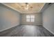 Spacious primary bedroom boasts modern floors, a tray ceiling with ceiling fan, and a large window at 3045 Flat Shoals Rd, Atlanta, GA 30349