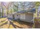 Back of house with patio and wooded backyard at 1832 Vauxhall Dr, Lithonia, GA 30058
