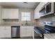 Modern kitchen featuring white cabinets, granite countertops, and stainless steel appliances at 1832 Vauxhall Dr, Lithonia, GA 30058