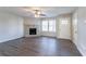 Spacious living room with wood-look flooring, a stone fireplace, and ceiling fan at 1832 Vauxhall Dr, Lithonia, GA 30058