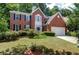 Charming two-story brick home with blue shutters, manicured lawn, and attached two-car garage at 1999 Riverlanding Cir, Lawrenceville, GA 30046