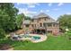 Luxury home backyard featuring a beautiful in-ground pool, spa, lounge area and lush landscaping at 3215 Kylee Dawn Cir, Lawrenceville, GA 30045