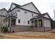 Rear view of two story home with covered patio and brick accents at 3065 Barnes Mill Ct, Roswell, GA 30075