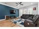 Spacious living room with dark leather sectional sofa and a blue accent wall at 1706 Pardee Dr, Kennesaw, GA 30152