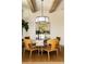 Bright dining room features a round glass table with wood chairs, a stylish light fixture, and exposed wooden beams at 6055 Tattnall Overlook, Acworth, GA 30101