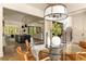 Elegant dining room with a view of the kitchen and living areas, featuring a glass-top table and modern lighting at 6055 Tattnall Overlook, Acworth, GA 30101