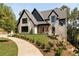 Two-story house with light brick and dark roof, showcasing a charming front porch and landscaping at 6055 Tattnall Overlook, Acworth, GA 30101