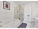 Bright bathroom featuring a glass shower, soaking tub, and double doors for toilet privacy at 6890 Peachtree Dunwoody Rd # 303, Atlanta, GA 30328