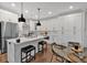 Stylish kitchen with white cabinets, stainless steel appliances, island with seating, and a dining table at 6890 Peachtree Dunwoody Rd # 303, Atlanta, GA 30328
