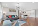 Bright living room open to kitchen features hardwood floors, modern lighting and comfortable seating at 6890 Peachtree Dunwoody Rd # 303, Atlanta, GA 30328