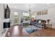 Comfortable living room features hardwood floors, contemporary lighting and access to a balcony with lovely view at 6890 Peachtree Dunwoody Rd # 303, Atlanta, GA 30328