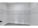Empty walk-in closet with carpet and white shelving at 6890 Peachtree Dunwoody Rd # 303, Atlanta, GA 30328