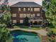 Exterior elevation of a brick home overlooking a backyard pool and patio at 3950 Stanford Dr, Cumming, GA 30041