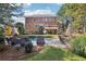View of the backyard featuring a pool, patio seating, lush lawn and a brick house at 3950 Stanford Dr, Cumming, GA 30041
