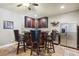 Well-equipped bar area featuring dark wood cabinets, bar with seating and a stainless steel refrigerator at 3950 Stanford Dr, Cumming, GA 30041