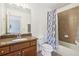 Bathroom featuring a granite vanity and a shower/tub combination with a patterned shower curtain at 3950 Stanford Dr, Cumming, GA 30041