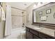 Well-lit bathroom featuring a granite countertop, dark wood cabinets and a tiled shower and bath at 3950 Stanford Dr, Cumming, GA 30041