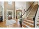 Spacious foyer with hardwood floors, staircase, and a lovely front door letting in natural light at 3950 Stanford Dr, Cumming, GA 30041