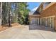 Three-car garage, basketball court, tall evergreens, and brick exterior at 3950 Stanford Dr, Cumming, GA 30041
