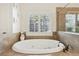 Garden tub with tile surround and plantation shutters in a main bathroom at 3950 Stanford Dr, Cumming, GA 30041