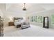 Bright main bedroom featuring tray ceilings, sitting area and large windows with plantation shutters at 3950 Stanford Dr, Cumming, GA 30041