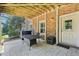 Covered patio area with an outdoor table and chairs with views of the brick home's exterior at 3950 Stanford Dr, Cumming, GA 30041