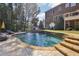 Backyard pool with surrounding patio and steps up to the elevated brick house at 3950 Stanford Dr, Cumming, GA 30041