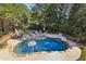 Aerial view of a beautiful backyard pool with lounge chairs and patio furniture surrounded by mature trees at 3950 Stanford Dr, Cumming, GA 30041