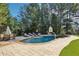Inviting backyard pool with a basketball hoop and beautiful stone patio surrounded by lush landscaping at 3950 Stanford Dr, Cumming, GA 30041