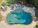 Inviting freeform pool surrounded by a stone patio, lounge chairs, and lush landscaping at 3950 Stanford Dr, Cumming, GA 30041