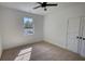 Spacious bedroom with neutral carpet, ceiling fan, and window offering natural light at 520 Mountainview Dr, Covington, GA 30016