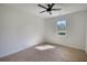 Well-lit bedroom with neutral carpet, ceiling fan, and large window at 520 Mountainview Dr, Covington, GA 30016