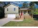 Newly constructed home featuring a light green exterior, a red front door, and a two-car garage at 520 Mountainview Dr, Covington, GA 30016