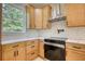 Modern kitchen with light wood cabinets, quartz countertops, and stainless steel appliances at 520 Mountainview Dr, Covington, GA 30016