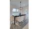 Stylish dining room with a black table, comfortable white chairs, and contemporary chandelier at 405 Carrera Ln, Acworth, GA 30102