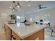 Modern eat-in kitchen island with white countertops, stainless steel sink, and view of the living room at 405 Carrera Ln, Acworth, GA 30102