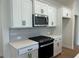 This kitchen features stainless steel appliances, white cabinets, and quartz countertops at 405 Carrera Ln, Acworth, GA 30102