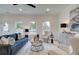 Bright living room featuring a blue sofa, neutral armchairs, stylish decor, and ample natural light from large windows at 405 Carrera Ln, Acworth, GA 30102