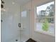 Glass enclosed shower with black hardware, bright window, and neutral tile at 405 Carrera Ln, Acworth, GA 30102