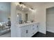 Bright white bathroom with dual sinks, stylish lighting, and hexagon tile floors at 401 Carrera Ln, Acworth, GA 30102