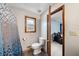 Simple bathroom with a shower/tub combo, toilet, and wood-framed window at 4036 Evelyn Dr, Powder Springs, GA 30127