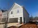 A new construction home features a two car garage with a concrete driveway under a sunny sky at 417 Carrera Ln, Acworth, GA 30102